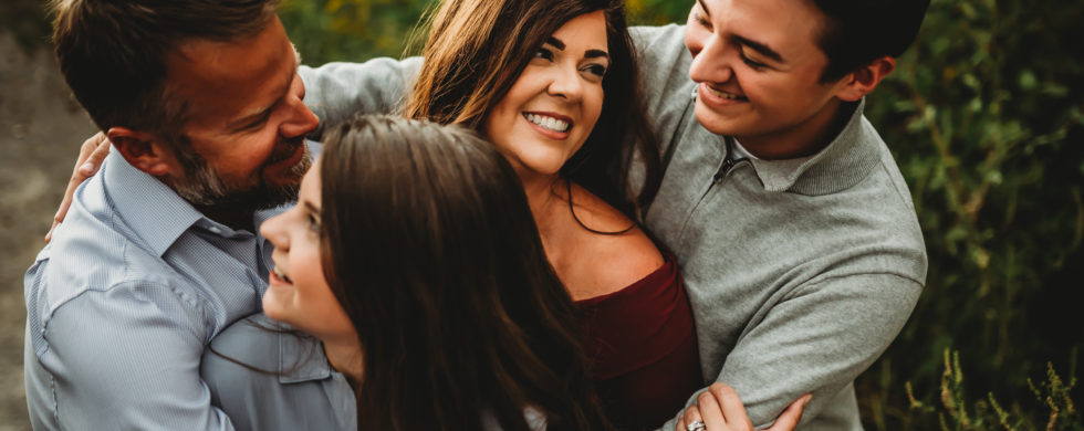 Family with older kids in a group hug